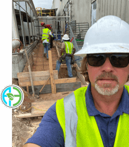 Construction workers wearing safety gear at a building site.